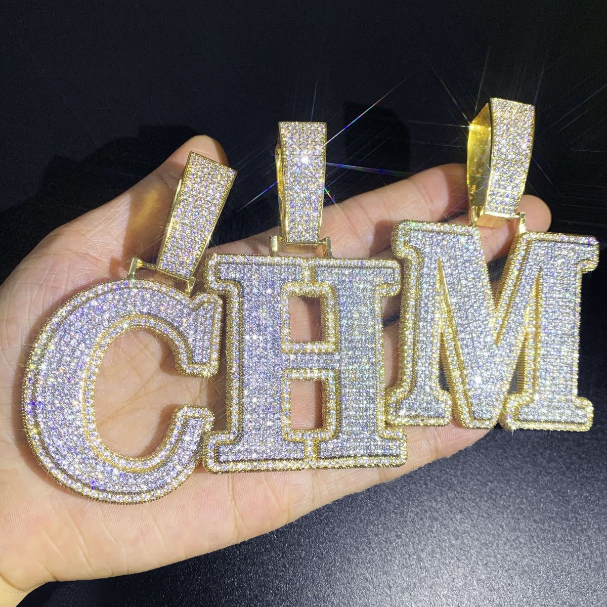 IceGrind gold initial pendant collection showing letters C, H, and M. Custom iced-out gold initial pendant necklaces.