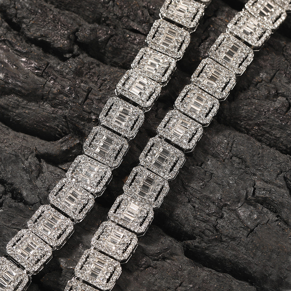 Close-up of 13MM white gold tennis chain links laid flat on a dark textured surface