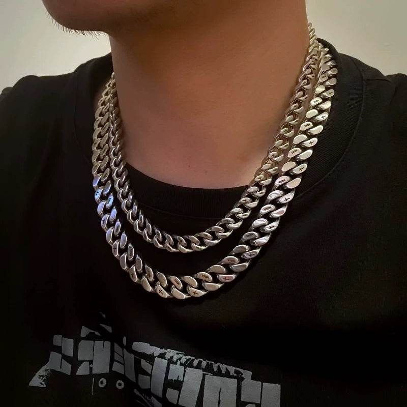 Layered white gold Miami Cuban link chain worn around the neck against a neutral background