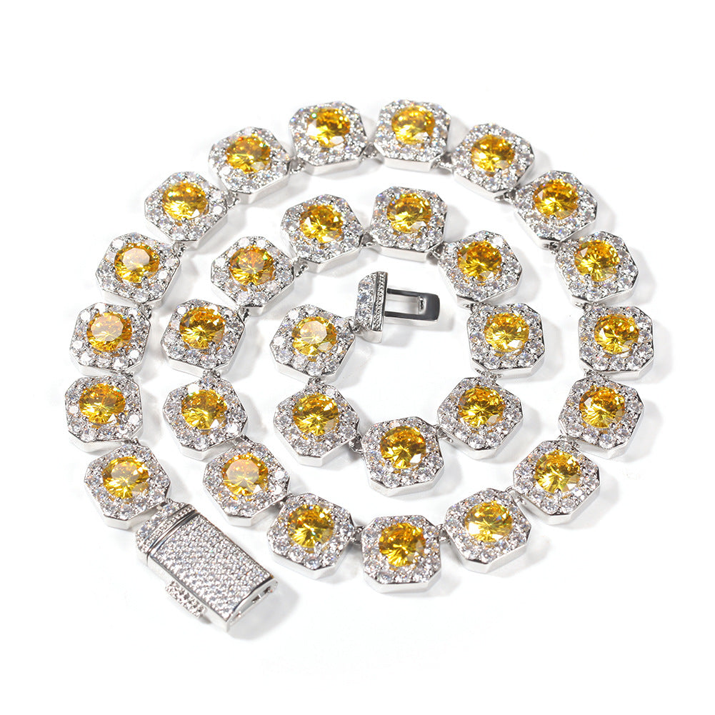 Coiled 12MM gold tennis chain against a white background showing its wide link structure with its box clasp visible