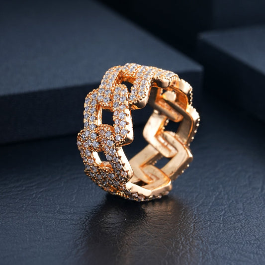 Gold-tone Cuban link ring with pavé-set stones, viewed from the side and top on a dark surface