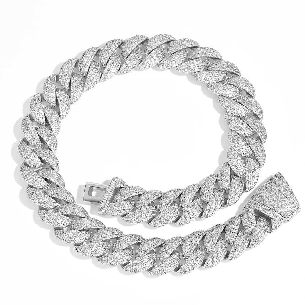 Coiled 24MM white gold Cuban link chain against a white background showing its wide link structure with its box clasp visible