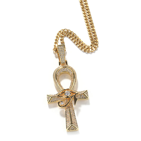 Gold-tone ankh pendant with an Eye of Horus design on a tennis chain against white