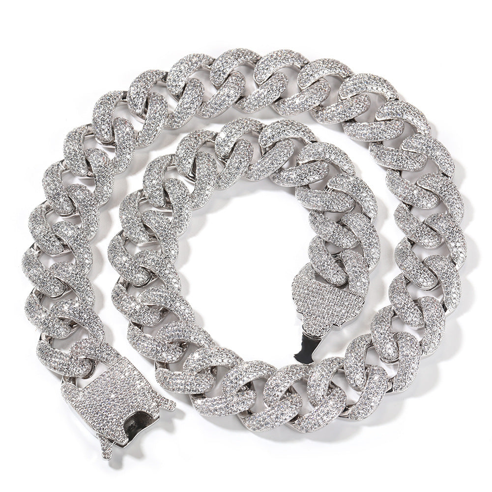 Coiled 20MM white gold Cuban link chain against a white background with its box clasp visible