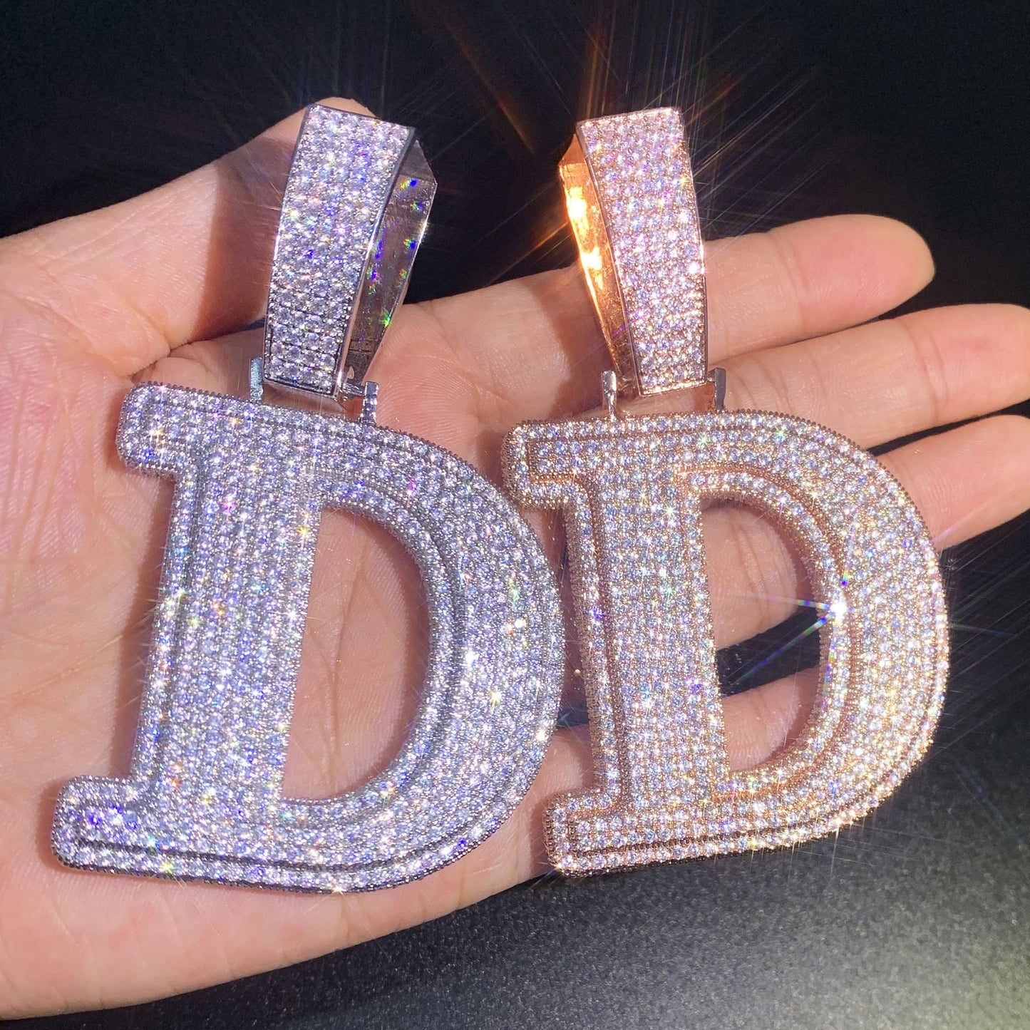 Color comparison of the oversized IceGrind initial pendant. Massive D pendants in silver and rose gold, featuring hand-set simulated diamonds on an 18K PVD-plated base.
