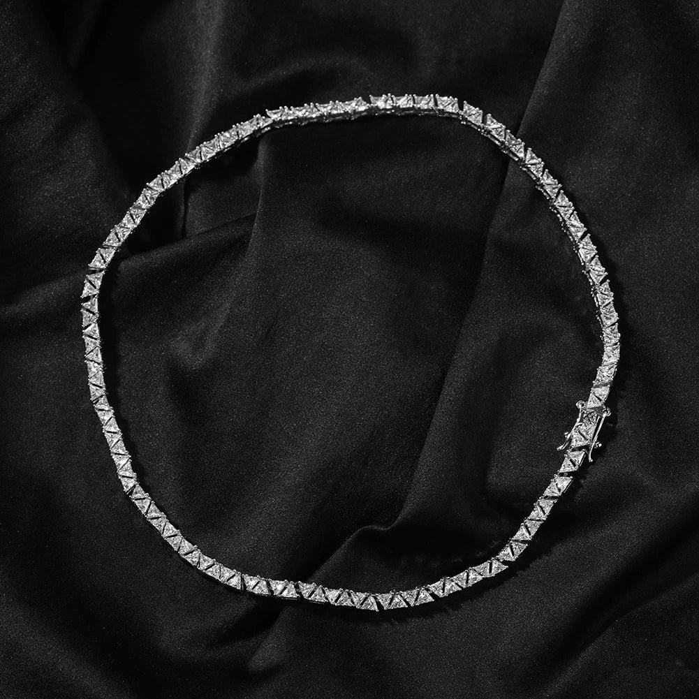 5MM white gold pyramid tennis chain displayed in a circular loop on a dark textured surface with its clasp visible