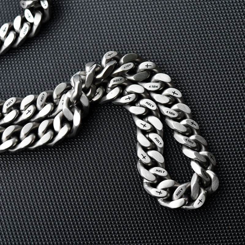 Coiled white gold Miami Cuban link chain on a dark textured surface showing its wide link structure