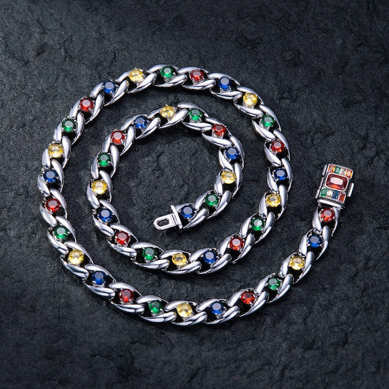 Coiled Miami Cuban link chain on a dark textured surface with its box clasp visible
