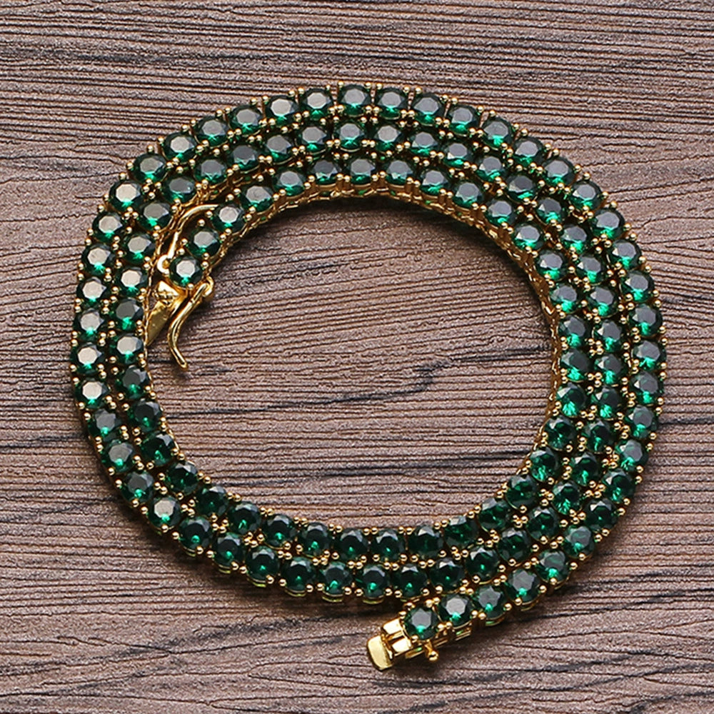 4MM gold tennis chain coiled in a circular shape on a wooden surface with its box clasp visible
