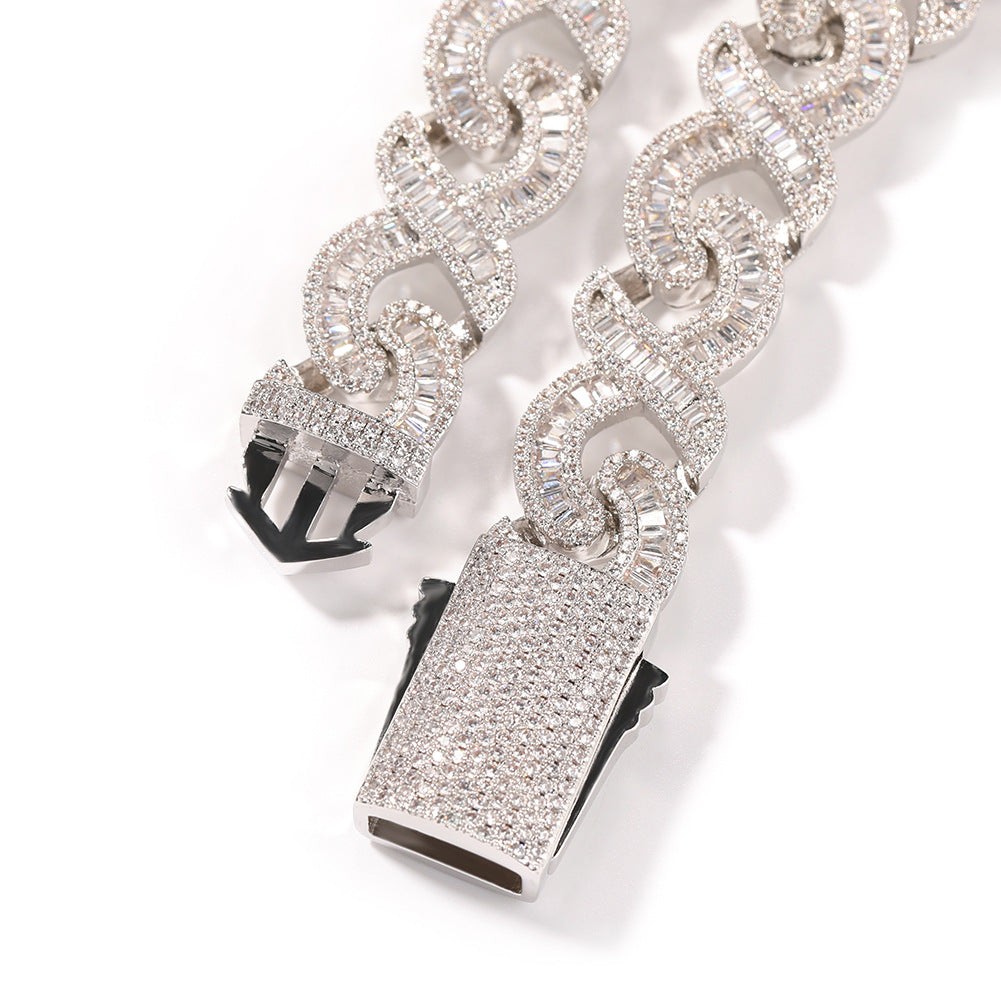 Close-up of Miami Cuban link chain links and box clasp laid flat against a white background
