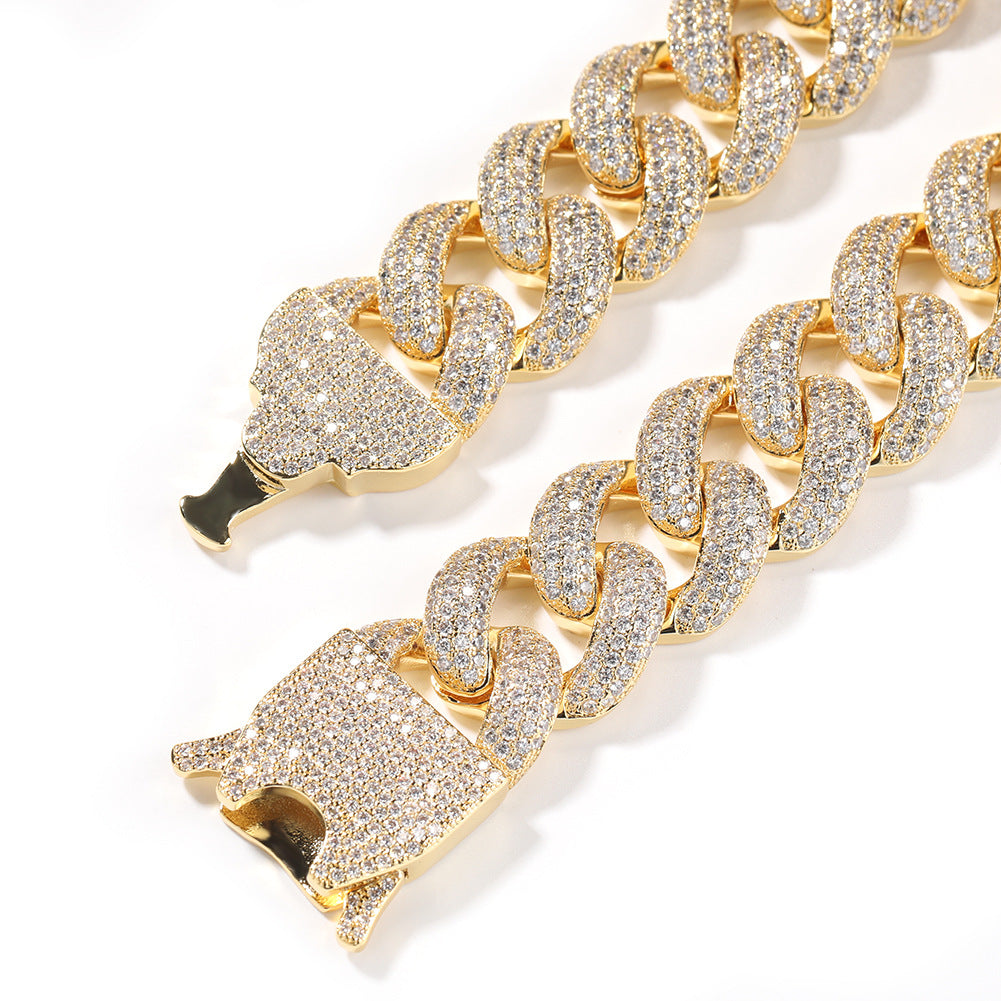 Coiled Miami Cuban link chain against a white background showing its wide link structure with its box clasp visible