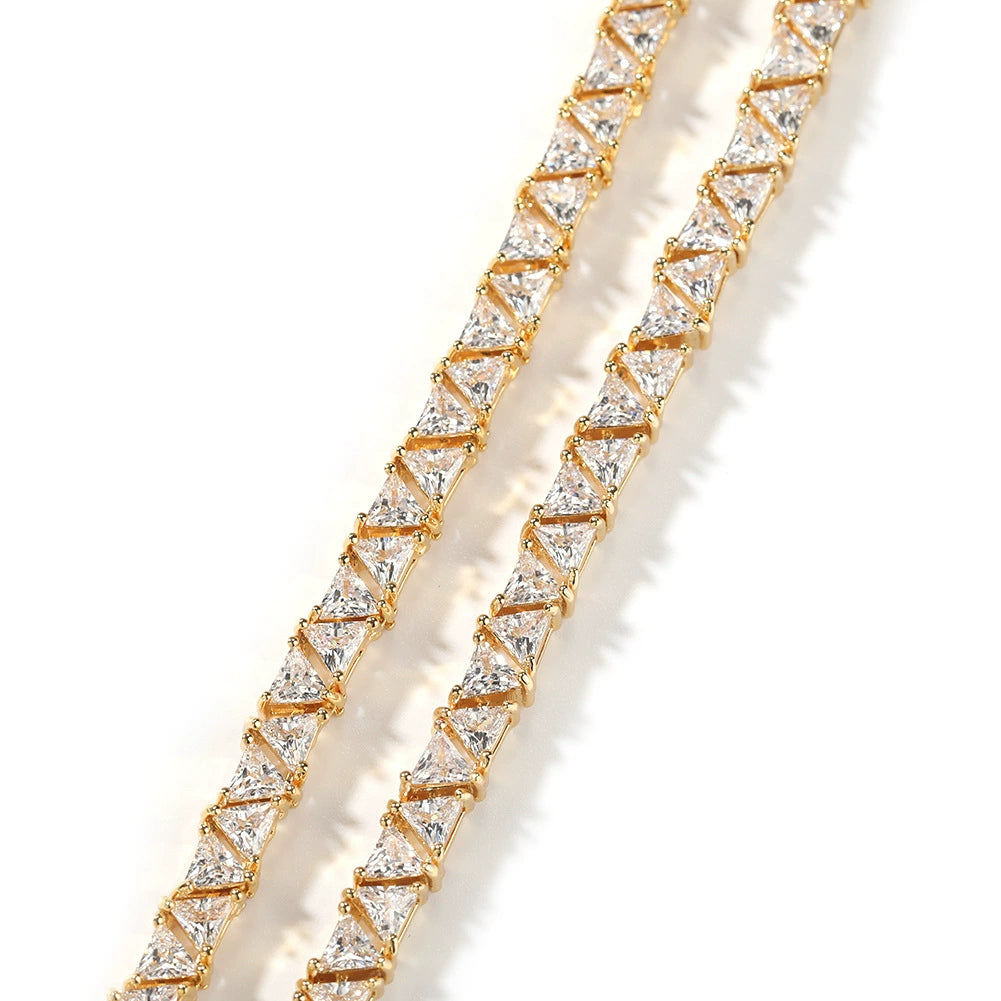 Close-up of 5MM gold pyramid tennis chain links laid flat against a white background