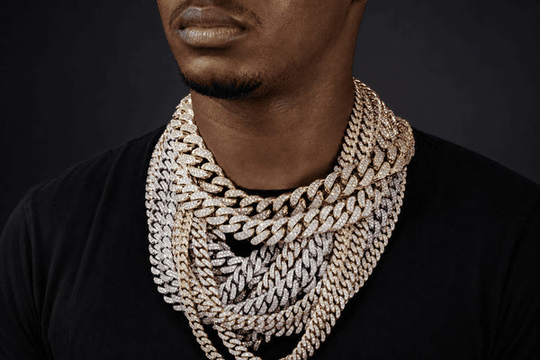 IceGrind men’s Cuban link chain collection featuring layered iced out Cuban chains in gold and silver tones on a Black male model