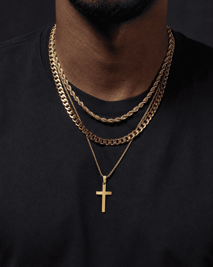 IceGrind gold chain close-up with layered gold chains and a cross pendant on a black shirt