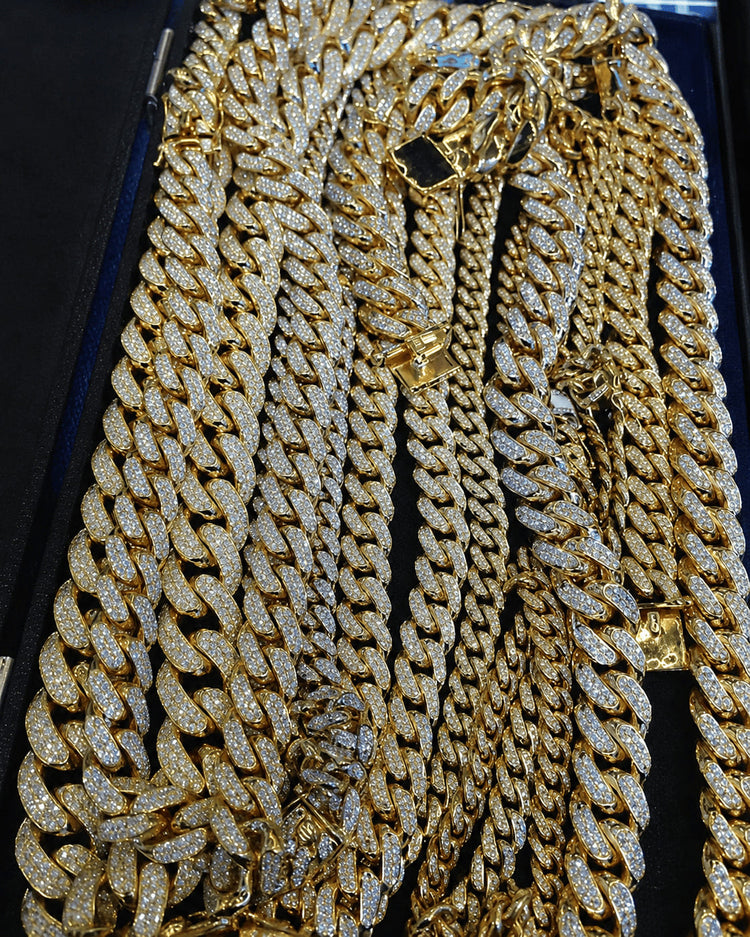 IceGrind gold Cuban link chain close-up with iced Cuban links and diamond shine on a black display